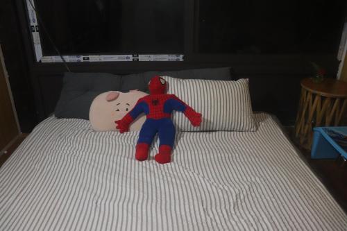 a stuffed spider man laying on top of a bed at Atash Eco Village Homestay Van Hoi in Quân Khê