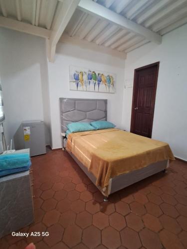 a bedroom with a bed with a painting of birds on the wall at Apto Comodo cerca de Centro de Puerto La Cruz in Puerto La Cruz