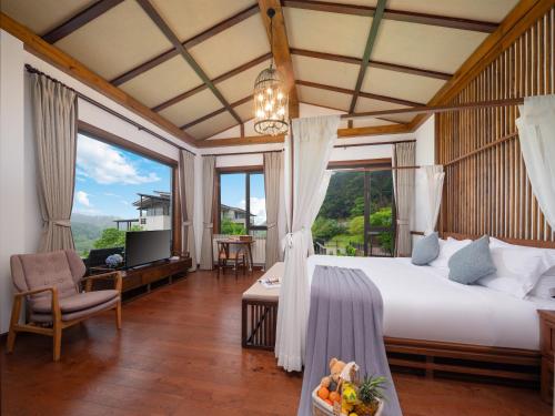 a bedroom with a bed and a large window at 莫干山缦田生态度假酒店 in Deqing