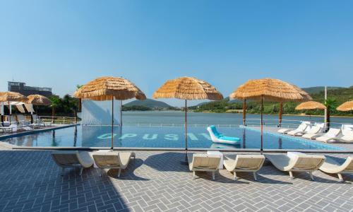a swimming pool with chairs and umbrellas at Opus11 Poolvilla in Gyeongju