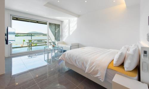 a bedroom with a bed and a view of the ocean at Opus11 Poolvilla in Gyeongju