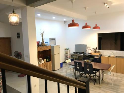 AmpitiyaにあるKandy Brick Bungalowのテーブルと椅子のあるキッチンとリビングルーム