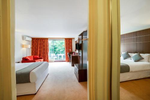 a hotel room with two beds and a window at The Bridge House Hotel in Reigate