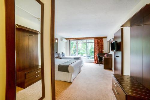 a hotel room with a bed and a mirror at The Bridge House Hotel in Reigate