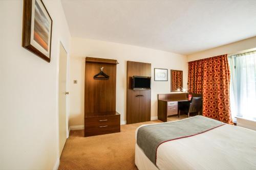 a hotel room with a bed and a desk at The Bridge House Hotel in Reigate