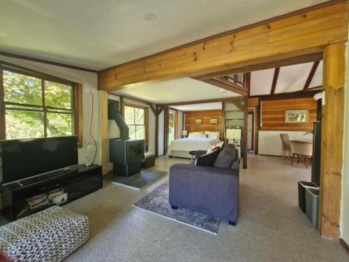 a large living room with a bed and a tv at Goorongoola in Wollombi