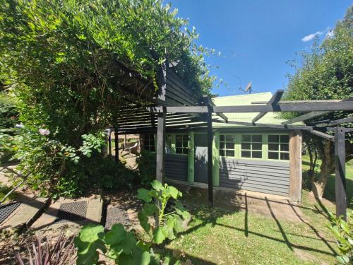 a small white house with a green door at Goorongoola in Wollombi