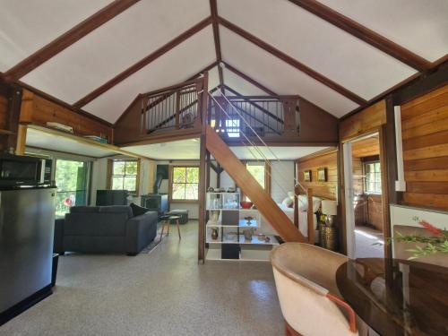 a living room with a spiral staircase in a house at Goorongoola in Wollombi