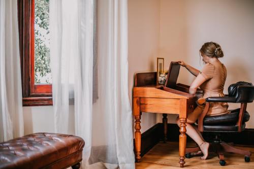 a woman sitting at a desk in front of a computer at Littlebourne Guest House in Bathurst