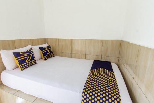 a bed in a room with pillows on it at Hotel O Penginapan Mekar Sari Near PT. Lombok Menara Energygas in Kuripan