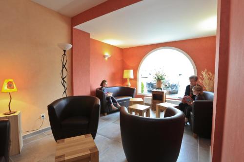 a waiting room with people sitting in chairs and a window at Logis Hotel Spa Restaurant Le Provence in Lanarce