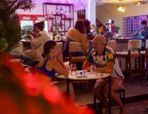 a group of people sitting at a table in a restaurant at Bliss & Beats Hostel in Phnom Penh