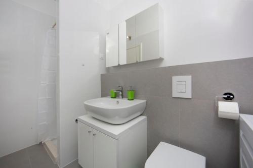a white bathroom with a sink and a toilet at Luxury Apartment "Ema", sea view in Split