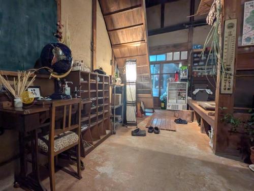 a room with a desk and a table with shoes at Koyado Namiji in Matsue