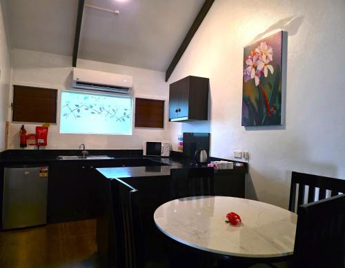 a kitchen with a table and a tv in it at Tokatoka Resort Hotel in Nadi