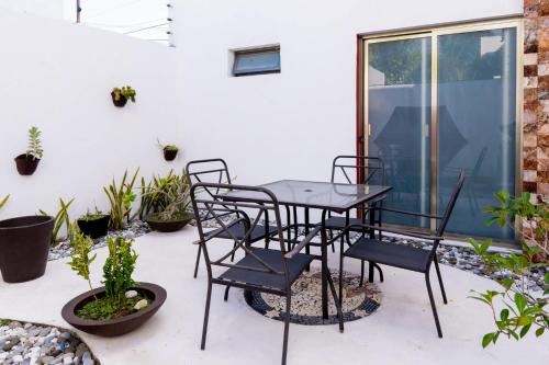 a table and chairs on a patio with plants at PENINSULA STAYS 3 BR House & AC + Private Parking + FAST WIFI in Chetumal