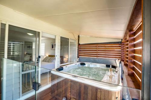 a bath tub in a room with a glass wall at 24 Laurie Ave Encounter Bay - Linen Included in Encounter Bay