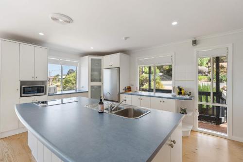 a kitchen with white cabinets and a large counter top at 24 Laurie Ave Encounter Bay - Linen Included in Encounter Bay