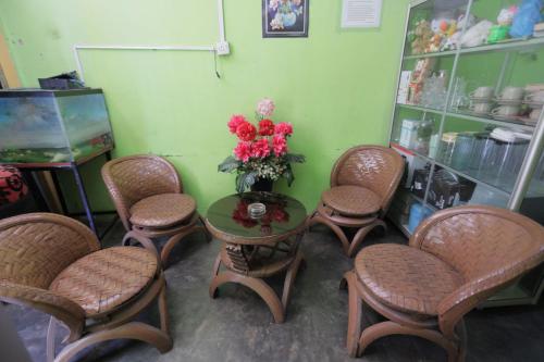 un groupe de chaises et une table avec un vase de fleurs dans l'établissement Hotel O Penginapan Mak YesNearTaman Buluh Hang Tuah, à Batam Center