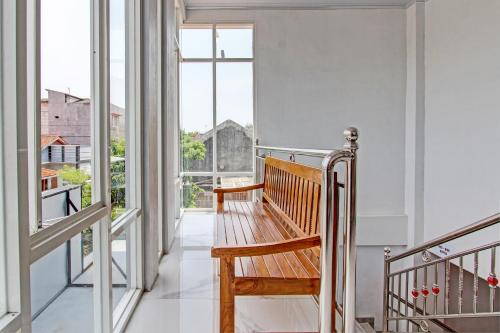 a hallway with a wooden bench on a balcony at Hotel O Muula Homestay Syariah in Pati