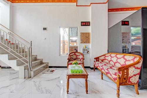 a living room with a couch and a chair at Hotel O Muula Homestay Syariah in Pati