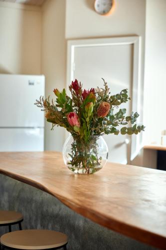 a vase of flowers sitting on a table at Rustic Treehouse - Aireys Inlet in Aireys Inlet