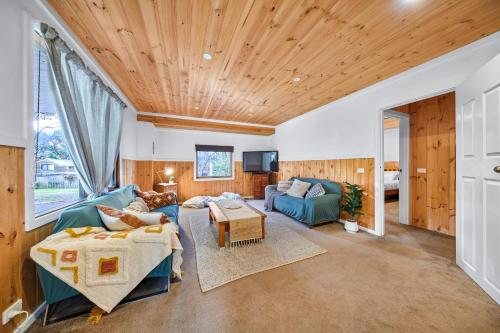 un soggiorno con pannelli in legno e soffitto in legno di Rustic Treehouse - Aireys Inlet ad Aireys Inlet