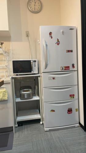 a kitchen with a refrigerator and a microwave at 伊豆の観海荘 in Ito