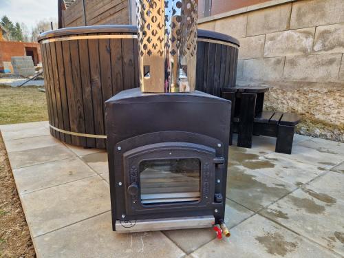 a fireplace on a patio with two trash cans at Relax Vila Lipno 1 u pláže Windy Point in Černá v Pošumaví