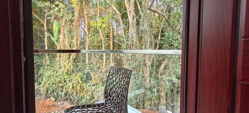 a black and white chair sitting outside a window at Rv Resorts Yercaud in Yercaud