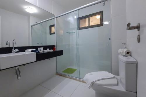a bathroom with a shower and a toilet and a sink at Wai Wai Cumbuco Vista Lateral Mar 2 Quartos in Guagiru