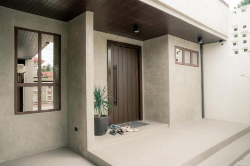 a front door of a house with a potted plant at Balai Mabini in Bantug