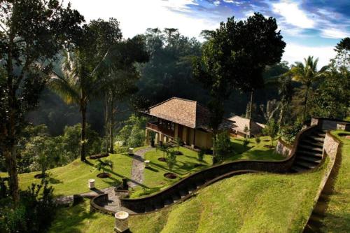 a house in the middle of a lush green field at Bagus Jati Health & Wellbeing Retreat in Tegalalang
