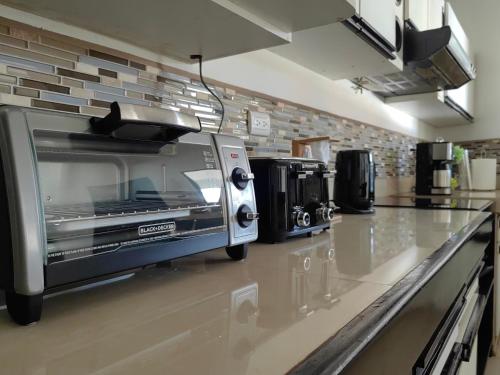 a toaster oven sitting on a counter in a kitchen at Hotel Boutique CasAguacate close to Airport, Pedregal, Centro de Convenciones de Costa Rica in Potrerillos