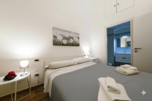 a white bedroom with a large bed and a table at Casa Vacanza La Fornace Matera centro in Matera
