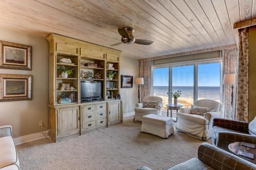Una sala de estar con un sofá y un televisor. en Oceans Of Amelia Condo, en Fernandina Beach