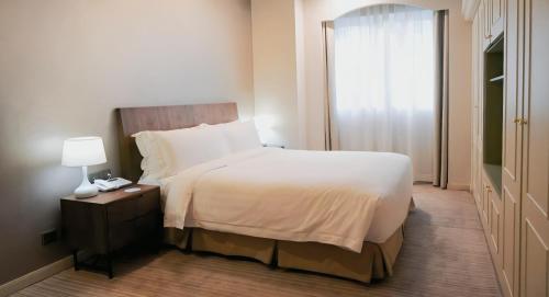 a hotel room with a bed and a window at Green Court Residence City Center, Shanghai in Shanghai