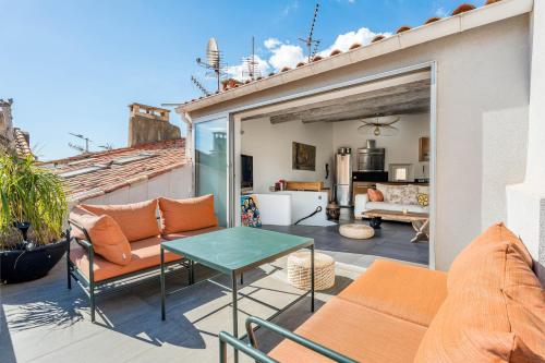 d'une terrasse avec un canapé et une table sur un balcon. dans l'établissement Le Duplex tropézienne par Dodo-a-Cassis, à Cassis