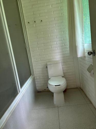 a bathroom with a white toilet and a shower at Casa Soñada a la Orilla del Rio in Conca