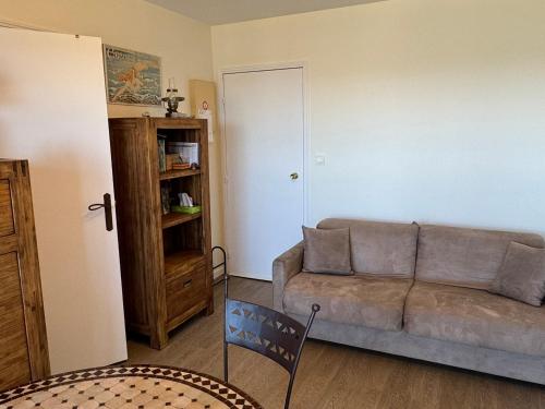 un salon avec un canapé et une table dans l'établissement Studio en bord de mer avec balcon et vue imprenable, accès direct plage - FR-1-487-317, à Cabourg
