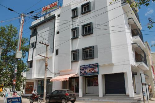 a white building on the corner of a street at Kalyan Residency By Azalea in Madurai