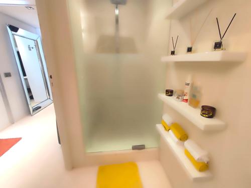 La salle de bains est pourvue d'une douche et d'un tapis jaune. dans l'établissement Superbe apartement vue panoramique sur la mer, à Cannes