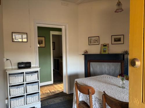 a dining room with a table and a green wall at The Smelters Home Burra in Burra
