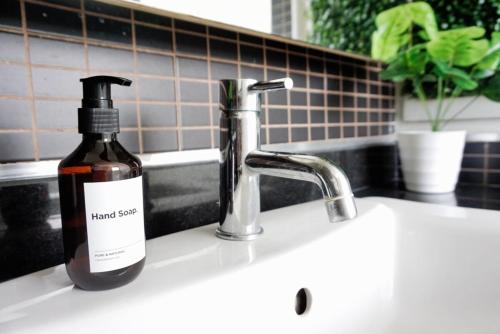 een fles handzeep die op de gootsteen in de keuken staat bij Executive Suite 1BR and Sofa Bed 150m to Nana BTS in Bangkok