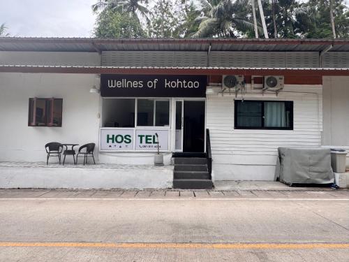 a white building with a hos te sign on it at WELLNESS of KOH TAO in Koh Tao