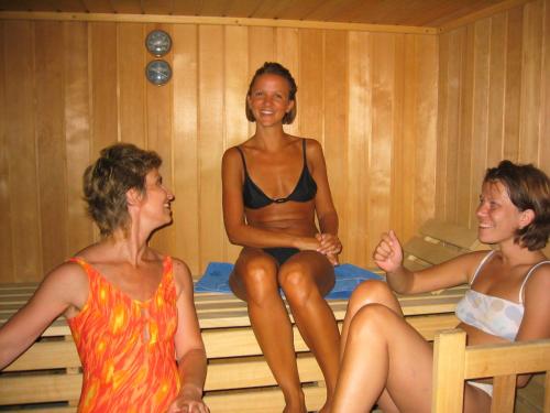 three women sitting on a bed in a sauna at Landhaus Hindenburg in Bad Gleichenberg