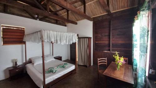a bedroom with a canopy bed and a table at Square de Vohémar in Vohemar