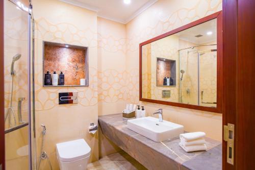 a bathroom with a sink and a toilet and a mirror at Eternal Oasis by Alaya Stays, Golf Course Road in Gurgaon