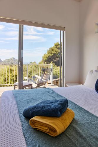 a bedroom with a bed with a blue blanket on it at Ruru House in Auckland