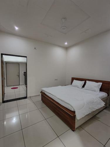 a white room with a bed and a mirror at Prem NATH Homestay in Garudeshwar